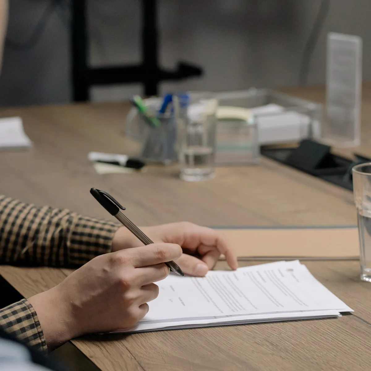 Dos personas repasando un contrato en la mesa de reuniones antes de firmarlo